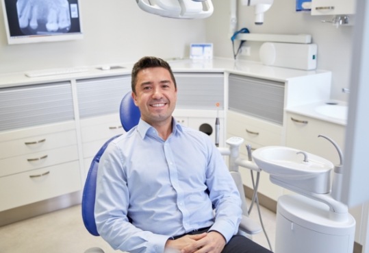 Smiling man sitting in dental chair in Farmington Hills dental office