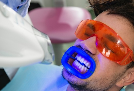 Man having his teeth professionally whitened in dental office