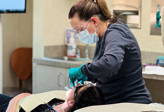 Farmington Hills dental team member showing a patient their new smile in mirror