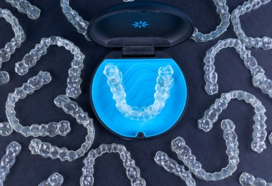 Several clear aligners on table with only one pair in carrying case