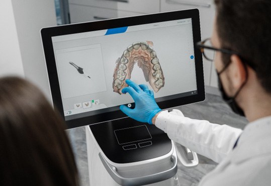 Dentist looking at scan of patient's teeth on screen