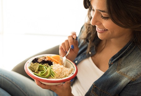 Closeup of smiling woman eating healthy meal