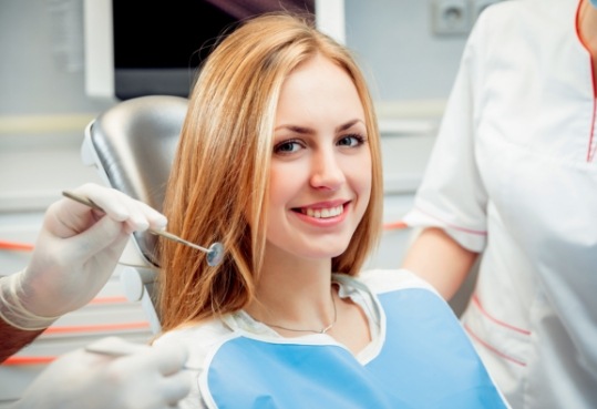 Young woman smiling in dental chair at preventive dentistry checkup