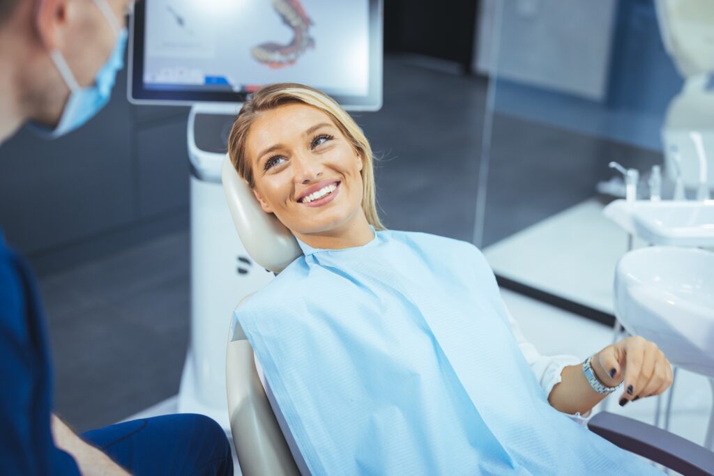 Woman smiling at dentist during Invisalign consultation